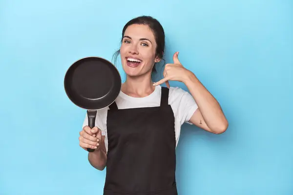 Woman Apron Pan Blue Background Showing Mobile Phone Call Gesture — Stock Photo, Image