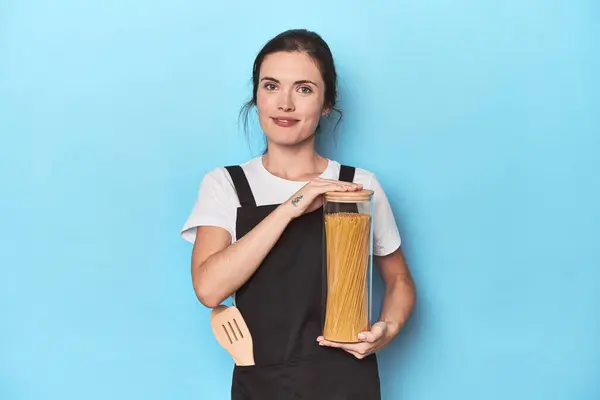 Young Chef Holding Pasta Jar Apron Blue — Stock Photo, Image