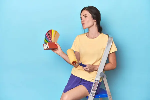 梯子のカラーパレット絵画の壁を持つ女性 — ストック写真