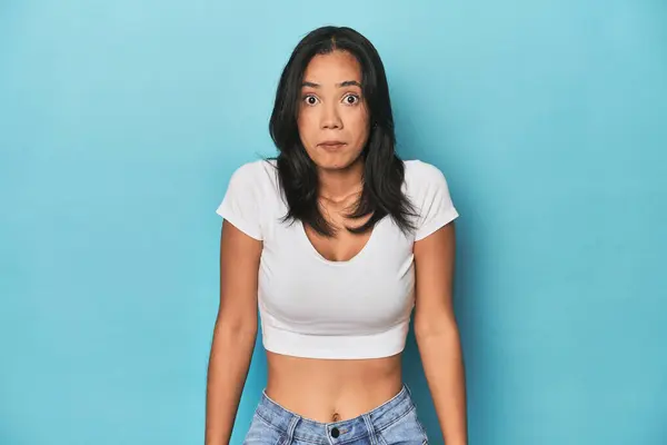 Filipina Young Woman Blue Studio Shrugs Shoulders Open Eyes Confused — Stock Photo, Image