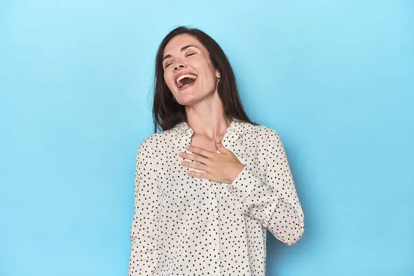 Young Caucasian Woman Blue Backdrop Laughs Out Loudly Keeping Hand — Stock Photo, Image
