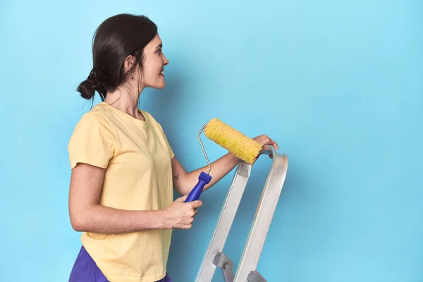 Merdivenden Mavi Bir Duvar Boyayan Kadın — Stok fotoğraf