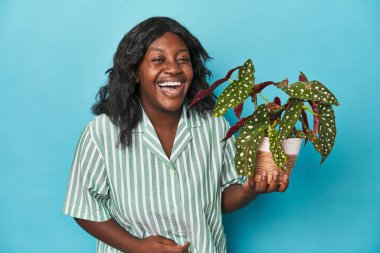 Kıvrımlı bahçıvan stüdyoda bitki tutuyor, gülüyor ve eğleniyor..