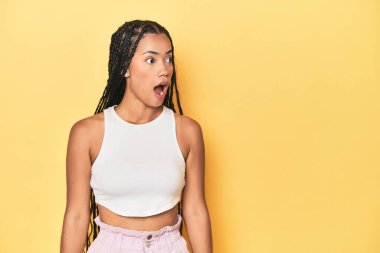 Sarı stüdyo arkaplanındaki genç Endonezyalı kadın gördüğü bir şey yüzünden şok oluyor..