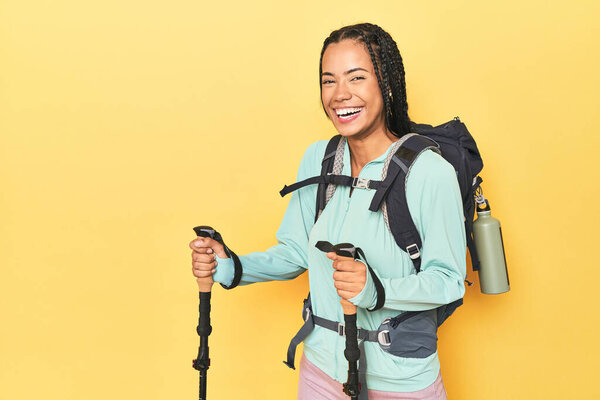 Индонезийский турист с рюкзаком и палками на желтом