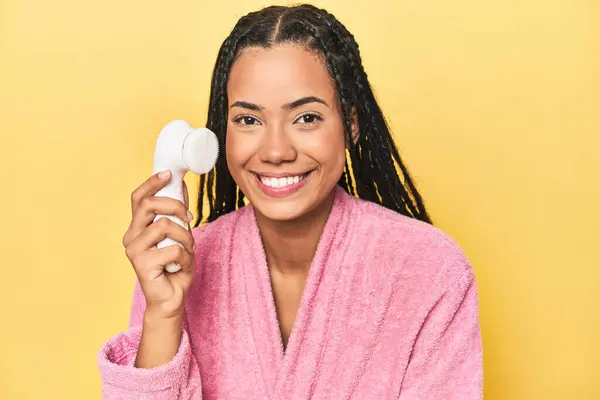 Young Indonesian Pink Robe Using Facial Cleaner Yellow Studio Backdrop — Stock Photo, Image