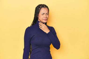 Sarı stüdyodaki genç Endonezyalı kadın virüs ya da enfeksiyon yüzünden boğazında ağrı hissediyor.