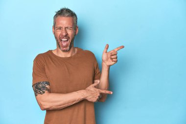 Mavi zemin üzerinde orta yaşlı beyaz bir adam işaret parmağıyla fotokopi alanını işaret ederek heyecan ve arzusunu ifade ediyor..