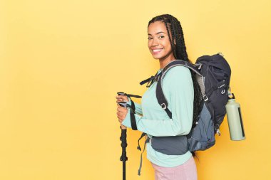 Sırt çantası ve sarı direkleri olan Endonezyalı yürüyüşçü