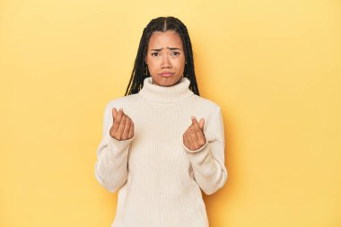 Sarı stüdyo arkaplanındaki genç Endonezyalı kadın parasız olduğunu gösteriyor..