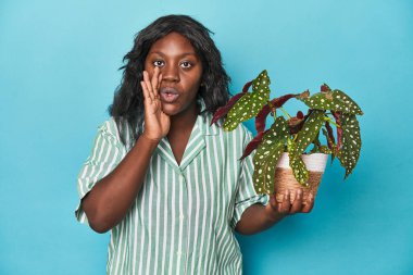 Stüdyoda elinde bitki tutan kıvrımlı bahçıvan gizli bir fren haberi veriyor.