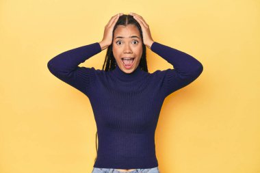 Sarı stüdyodaki genç Endonezyalı kadın çığlık atıyor, çok heyecanlı, tutkulu, bir şeyden memnun..