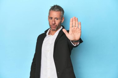 Beyaz iş adamı, mavi arka planda orta yaşlı.