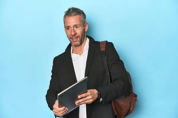 Businessman Backpack Holding Laptop Blue Backdrop — Stock Photo, Image