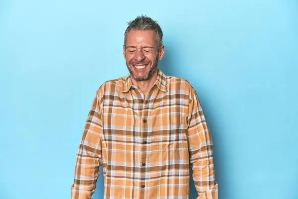 Middle Aged Caucasian Man Blue Backdrop Laughs Closes Eyes Feels — Stock Photo, Image