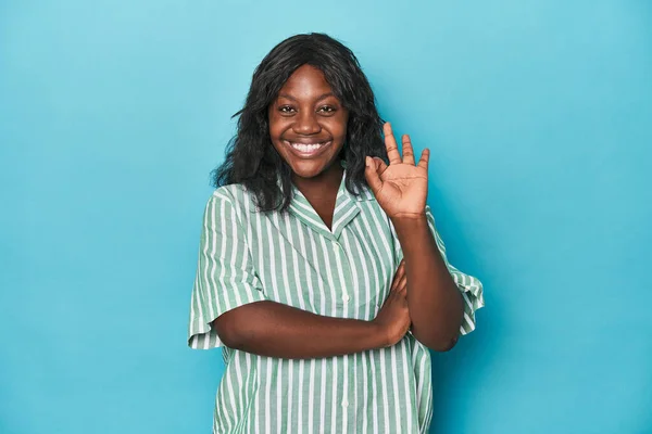 年轻的非洲裔美国卷曲女人眨了眨眼 用手握住一个好的手势 — 图库照片