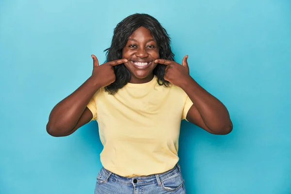Genç Afro Amerikan Kıvrımlı Kadın Gülümsüyor Parmaklarını Ağzına Doğrultuyor — Stok fotoğraf