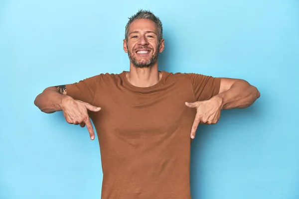 Middle Aged Caucasian Man Blue Backdrop Points Fingers Positive Feeling — Stock Photo, Image