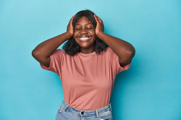 Young African American Curvy Woman Laughs Joyfully Keeping Hands Head — Stock Photo, Image