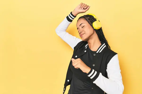 Indonesian Woman Baseball Jacket Headphones Yellow Studio Backdrop — Stock Photo, Image