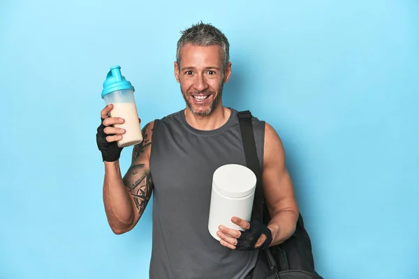Sportovec Drží Proteinový Koktejl Kontejner Modrém Pozadí — Stock fotografie