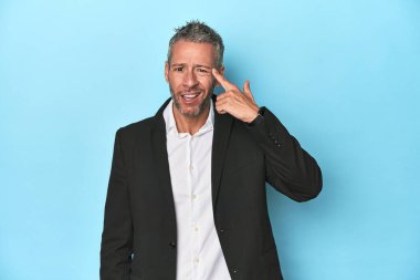 Beyaz iş adamı, mavi arka planda orta yaşlı.