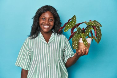 Kıvrımlı bahçıvan stüdyoda çiçek tutuyor. Mutlu, güler yüzlü ve neşeli..