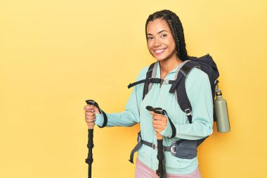 Sırt çantası ve sarı direkleri olan Endonezyalı yürüyüşçü