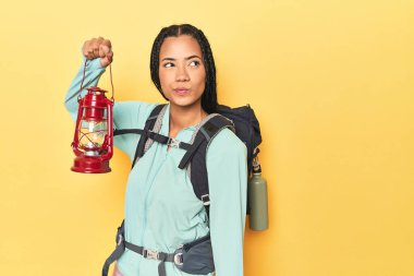 Endonezyalı yürüyüşçü sarı üzerinde taşınabilir fener tutuyor.