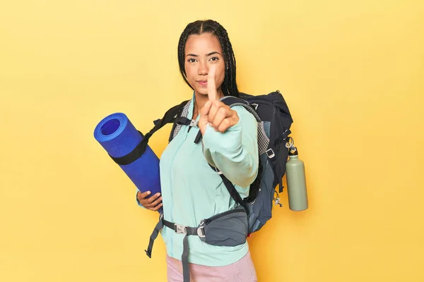 インドネシアの女性は指でナンバーワンを示す黄色の山の旅行の準備ができています — ストック写真