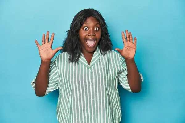 年轻的非洲裔美国卷曲女人得到了一个愉快的惊喜 兴奋地举起双手 — 图库照片