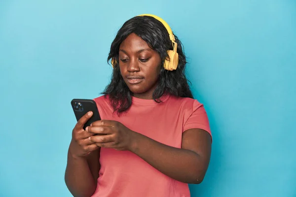 Kıvrımlı Kadın Telefon Kulaklıkla Müzik Dinliyor — Stok fotoğraf