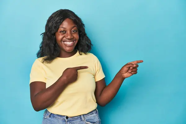 Young African American Curvy Woman Excited Pointing Forefingers Away — Stock Photo, Image