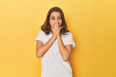 Güzel yetişkin bir kadının portresi şok olmuş, ağzı ellerle kaplanmış, yeni bir şey keşfetmek için sabırsızlanıyor..