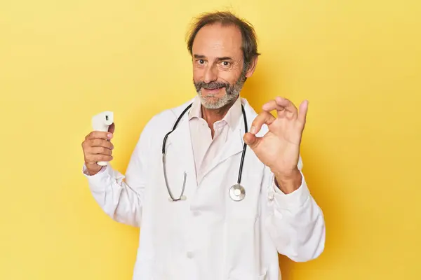 Doctor Holding Infrared Thermometer Studio Cheerful Confident Showing Gesture — Stock Photo, Image