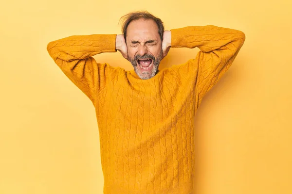 Caucasian Middle Aged Man Yellow Studio Covering Ears Hands Trying — Stock Photo, Image