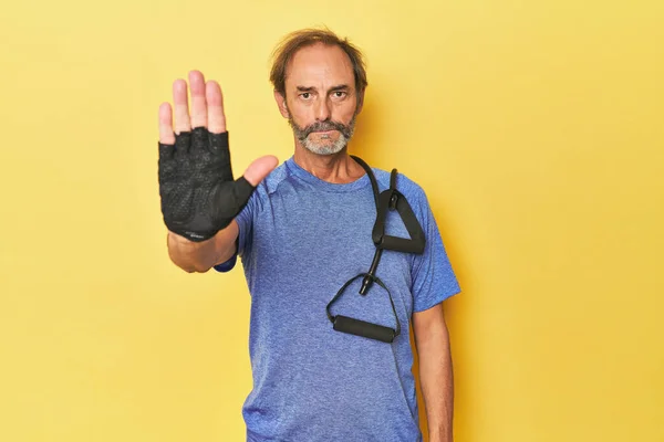 Homem Exercitando Com Bandas Estúdio Com Mão Estendida Mostrando Sinal — Fotografia de Stock