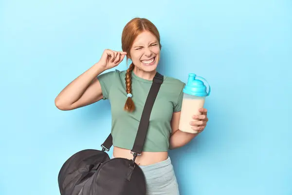 Redhead Holding Protein Shake Blue Studio Covering Ears Hands — Stock Photo, Image