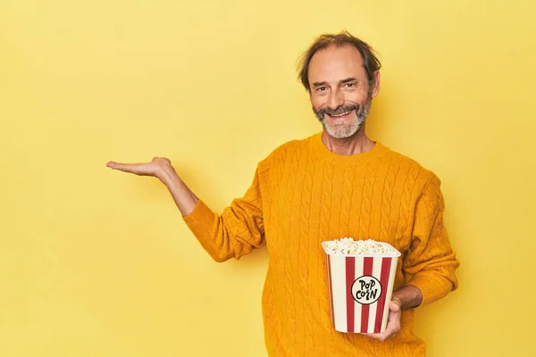 Man Enjoying Popcorn Yellow Studio Showing Copy Space Palm Holding — Stock Photo, Image