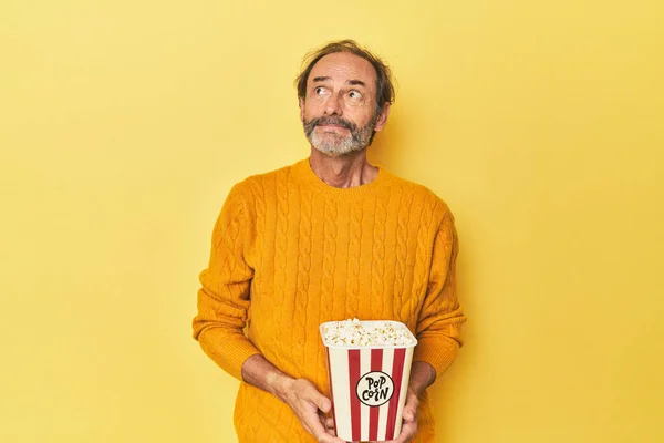 Man Enjoying Popcorn Yellow Studio Dreaming Achieving Goals Purposes — Stock Photo, Image