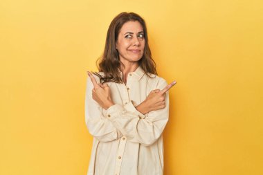 Güzel yetişkin kadın portresi iki seçenek arasında seçim yapmaya çalışıyor..