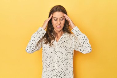 Güzel yetişkin bir kadının portresi tapınaklara dokunuyor ve baş ağrısı çekiyor..