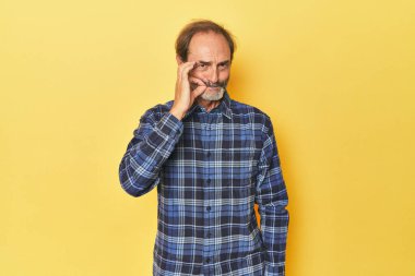 Sarı stüdyoda orta yaşlı, dudakları dudaklarında bir sır saklayan beyaz bir adam..