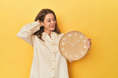 Güzel yetişkin bir kadının portresi başının arkasına dokunuyor, düşünüyor ve bir seçim yapıyor..