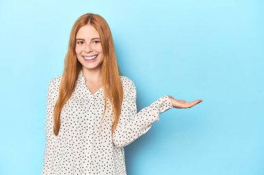 Mavi arka planda kızıl saçlı genç bir kadın avuç içinde fotokopi odası ve belinde bir el daha gösteriyor..