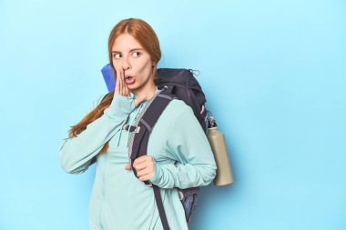 Stüdyoda sırt çantası ve paspas taşıyan kızıl saçlı gezgin gizli bir fren haberi veriyor ve yan bakıyor.