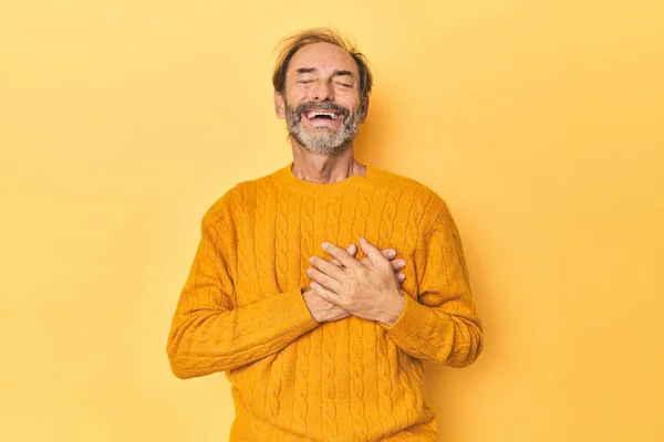 Caucasian Middle Aged Man Yellow Studio Laughing Keeping Hands Heart — Stock Photo, Image