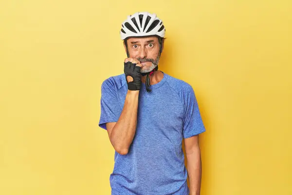 Sarı Stüdyoda Kask Takan Tırnaklarını Yiyen Gergin Endişeli Bir Bisikletçi — Stok fotoğraf
