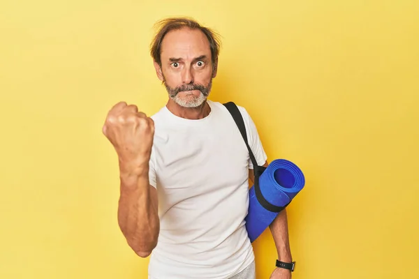 Man Yoga Mat Yellow Studio Showing Fist Camera Aggressive Facial — Stock Photo, Image