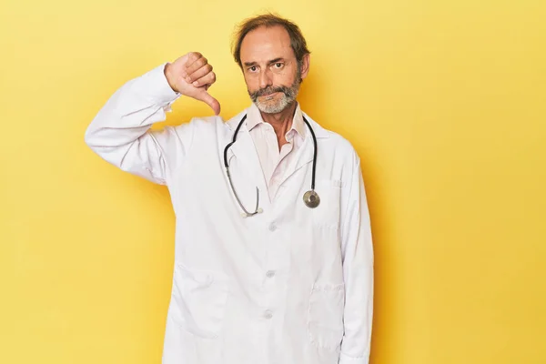 Doctor Con Estetoscopio Estudio Amarillo Mostrando Gesto Aversión Pulgares Hacia —  Fotos de Stock